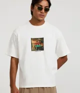 Remera de algodón color blanco, corte boxy, manga corta y cuello redondo. Presenta una estampa fotográfica localizada en el pecho de varios perros jugando al billar sobre una mesa verde.