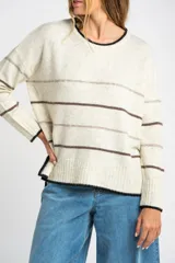 Sweater color crema con rayas horizontales en tonos marrón, bordeaux y beige.