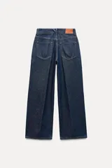 Pantalón de jean azul oscuro, de tiro alto y corte recto con pernera ancha.