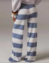 Pantalón de punto de tiro alto con cintura elástica y corte palazzo. Diseño a rayas horizontales anchas en color marrón y crudo.