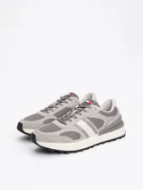 Zapatillas Tommy Jeans grises de corte bajo, con exterior de ante y malla, detalles distintivos de la marca, suela de goma dentada y cierre con cordones.