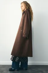 Trench color verde oscuro con cuello solapa combinado en pana marrón y manga larga. Detalle de acabados con trabillas y pinza en espalda. Bolsillos delanteros con solapa y botón a presión. Tejido encerado efecto lavado. Cierre frontal con botones a presión.