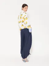 Pantalón largo de lino color blanco, de corte amplio y tiro alto. Presenta recortes en delantero y espalda, bolsillos escondidos al frente y bolsillos ojal en la parte posterior. Lleva jareta con lazo para ajustar y bordado marcario JCH en el delantero.