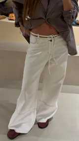 Pantalón de jean crudo de tiro bajo con pasacintos doble y corte recto. Presenta costuras a contratono y ruedo desflecado.