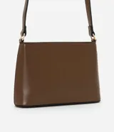 Cartera bandolera pequeña color crema, confeccionada en material sintético con cierre de cremallera y asa larga regulable.