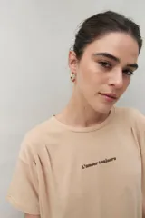 Remera color beige de manga corta con bordado frontal con la frase “L’amour toujours”.
