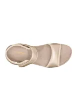 Sandalias blancas con detalles en gris, con ajuste de velcro en el tobillo y suela anatómica.