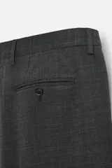 Pantalón de vestir azul marino, de corte slim fit, con bolsillos laterales y traseros. Se ajusta a la cintura con cinturón de cuero marrón.