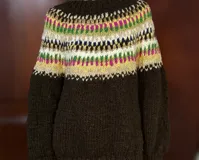 Sweater de lana merino con cuello redondo y diseño con motivos geométricos en tonos azul, marrón, naranja, verde y beige.
