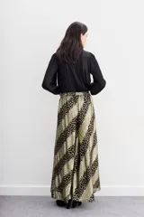 Pantalón amplio de viscosa jacquard con lurex, estampado con manchas de leopardo en negro y dorado. Tiene caída fluida, cintura con elástico trasero y forrería a tono.