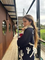 Campera azul marino con diseño de rodeo en la espalda, puños en color crema, cuello amplio y cierre frontal.