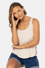 Musculosa beige con estampado de hojas y flores en tonos pastel, escote redondo y botones decorativos.