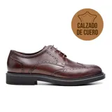Zapato de vestir acordonado negro de cuero con detalles de perforaciones y suela de goma.