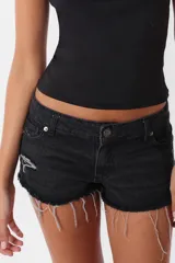 Short de jean negro con roturas, tiro medio, cintura con pasacintos, cierre y botón metálico.
