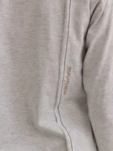 Remera gris claro de algodón con escote en V y bordados dorados y azul marino en los hombros.