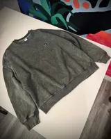 Buzo verde con efecto nevado, corte oversized y cuello redondo.