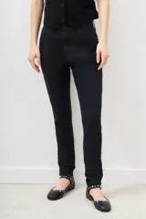 Pantalón de jean negro de tiro medio-alto y calce skinny. Con proceso de coating de acabado símil cuero.