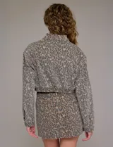 Campera de jean estampada con animal print de leopardo en tonos beige y gris, marca Hidden. Tiene cuello solapa, abertura frontal con botones metálicos, bolsillos delanteros y ruedo elastizado en la espalda.