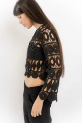 Blusa beige de hilo calado con mangas largas y cuello redondo.