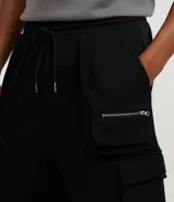 Bermuda masculina de algodón y poliéster, color marrón oliva, con cintura ajustable mediante cordón, pliegues frontales y múltiples bolsillos cargo con cierres metálicos.