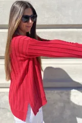 Sweater negro de tejido de punto con escote en V y rayas verticales plateadas.
