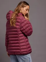 Campera acolchada color burdeos, con capucha y cierre frontal.