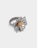 Anillo plateado con forma de margarita y centro dorado.
