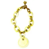 Collar de resina color amarillo con dije circular, diseñado en Francia, ajustable en longitud.