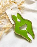 Caravanas de acrílico en color verde con borde de strass, de forma abstracta.