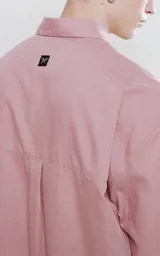 Camisa manga larga color rosa, de calce oversize, con bolsillo con ojal y botón en el delantero.