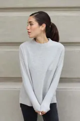 Sweater de tejido de punto color gris claro, de cuello redondo y calce holgado, confeccionado en lana italiana.