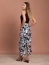 Pantalón capri estampado con flores en tonos celeste, blanco y negro. Tiene pretina elastizada en la parte trasera y bolsillos delanteros.