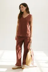 Pantalón de lino color ladrillo, de corte recto y tiro medio, con bolsillos laterales y traseros.