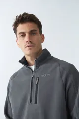 Buzo polar de algodón color bordó, con cuello elevado, medio cierre frontal, bolsillo con cierre en el pecho y logo estampado.