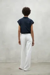 Camisa azul marino con cierre frontal de botones y dobladillo ajustable con cordones de tela.