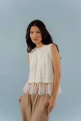 Chaleco de hilo color crudo con flecos en el ruedo.