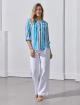 Blusa de gasa estampada con rayas verticales en tonos celeste, azul y blanco. Tiene cuello a la base con escote en V y abertura con botones. Las mangas largas son de largo regulable.