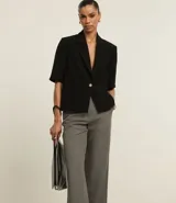 Pantalón recto de vestir color gris, de corte sastrero con cintura alta, trabillas y detalle de ganchillo en la cintura.
