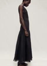 Vestido largo negro de lino y ramio, con cuello redondo, tirantes anchos y corte evasé.