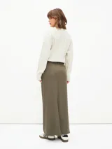 Falda midi negra de corte recto, con cintura alta, bolsillos laterales y cierre frontal con botón.