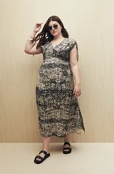 Vestido largo negro con estampado de líneas verticales blancas, escote en V, mangas cortas con lazo ajustable y corte fluido.