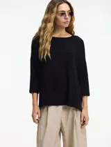 Sweater color crema de corte amplio, con cuello redondo y tajos laterales.