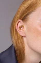 Ear cuff acabado en oro de 18k, diseño moderno y ligero, compatible con ambos lados de la oreja.