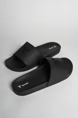 Chancletas negras con logo en relieve en la tira superior.