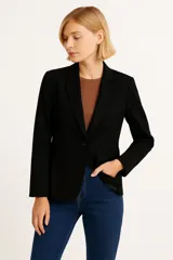 Blazer negro entallado con solapas de muesca, cierre frontal con un botón y bolsillos con solapa.
