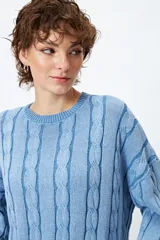 Sweater color beige con diseño de ochos en relieve, cuello redondo y corte oversize.