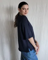 Sweater color beige de tejido de punto con mangas cortas y cuello redondo.