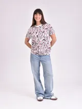 Remera estampada con motivos florales en tonos naranja, beige, gris y rosa.