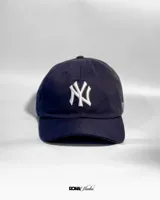 Gorro de béisbol azul marino con logo de los New York Yankees bordado en blanco en el frente y la palabra "Yankees" bordada en el lateral.