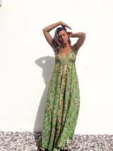 Vestido largo de seda verde con estampado paisley, escote halter y espalda descubierta.